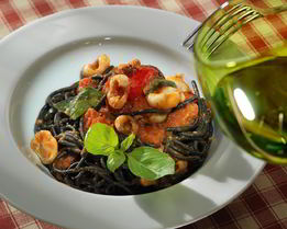 Черные спагетти с соусом из помидоров и каракатиц