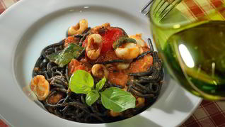 Черные спагетти с соусом из помидоров и каракатиц